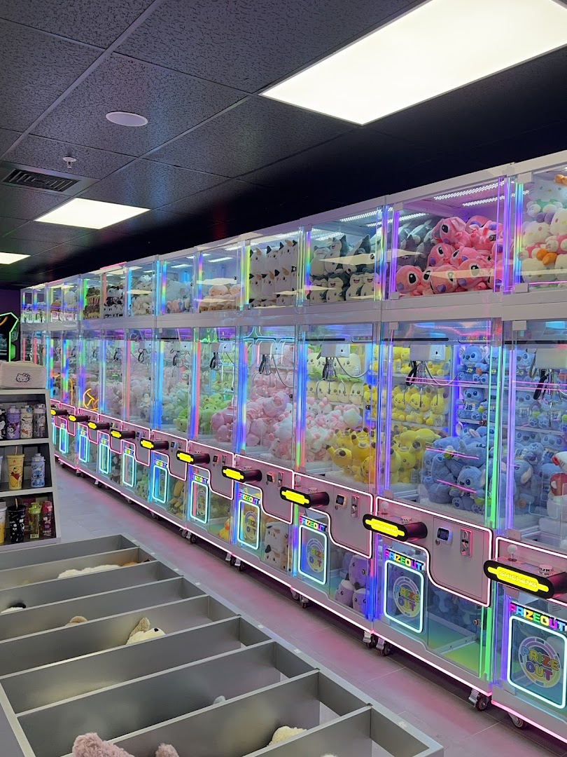 A glowing wall of claw machines stuffed with plushies at Arcadia